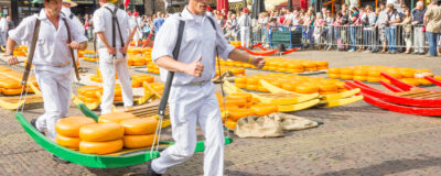 ALKMAAR, THE NETHERLANDS - SEPTEMBER 7: Carriers walking with many cheeses in the famous Dutch cheese market, September 7, 2012 in Alkmaar, The Netherlands. The event happens in the Waagplein square.