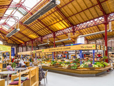 COLMAR, FRANCE - JULY 3, 2013: people shop in the old market hall in Colmar, France. Designed in 1865, this building returns to its original purpose of market hall in September 2010.