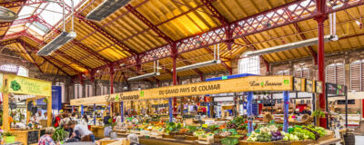 COLMAR, FRANCE - JULY 3, 2013: people shop in the old market hall in Colmar, France. Designed in 1865, this building returns to its original purpose of market hall in September 2010.