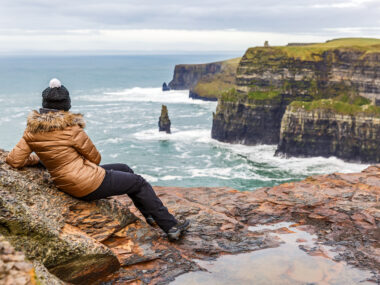 Young tourist woman admire the view at Cliffs of Moher