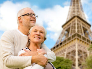 family, age, tourism, travel and people concept - happy senior couple hugging over paris eiffel tower in france