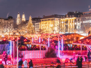 Festive Christmas markets in Zurich at night - Aerial view of lights and Christmas tree in Bellevue square with Grossmünster bell towers on background - Holidays and lifestyle concepts in Switzerland