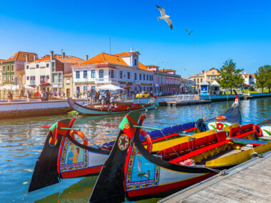 Traditional boats on the canal in Aveiro, Portugal. Colorful Moliceiro boat rides in Aveiro are popular with tourists to enjoy views of the charming canals. Aveiro, Portugal.