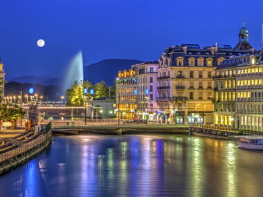 Urban view with famous fountain by night with full moon, Geneva, Switzerland, HDR